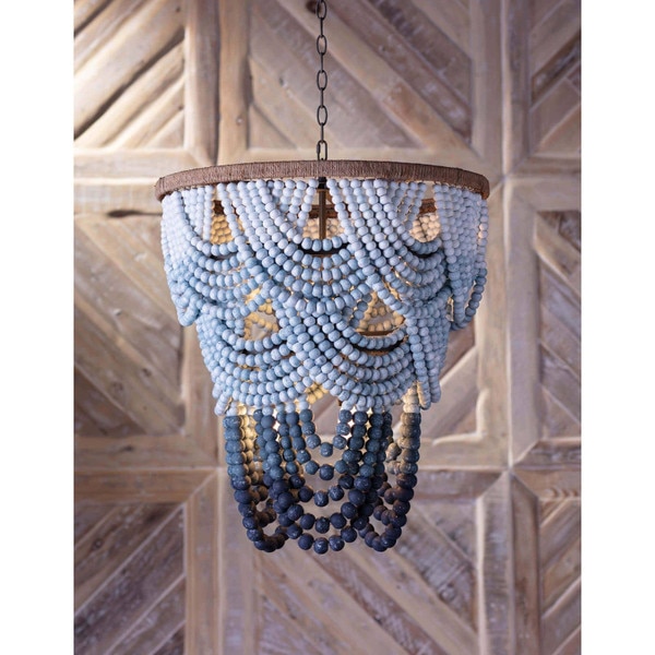 Blue wood beaded chandelier in front of a wood wall